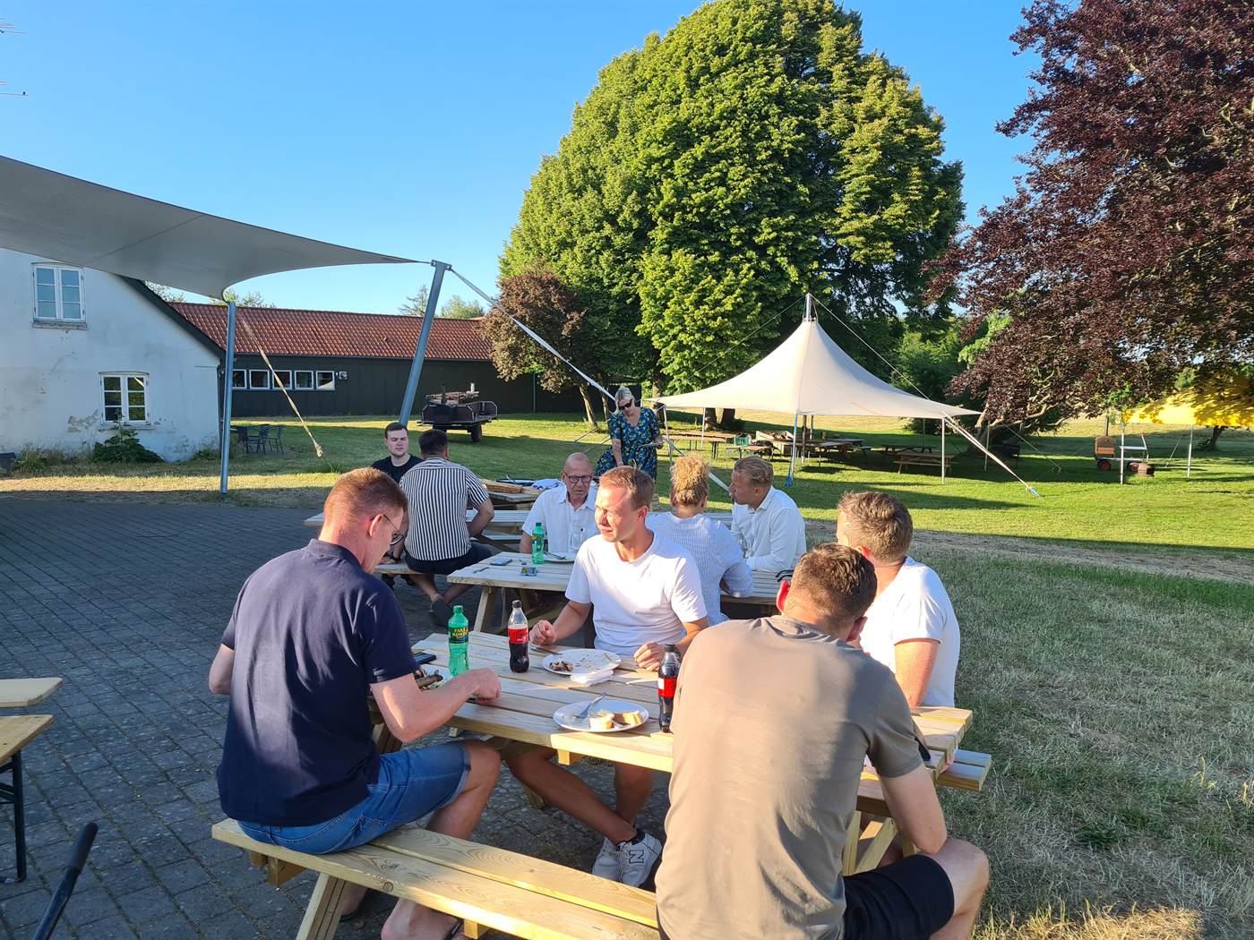 Deltagere spiser udendørs ved Houens Odde en sommeraften